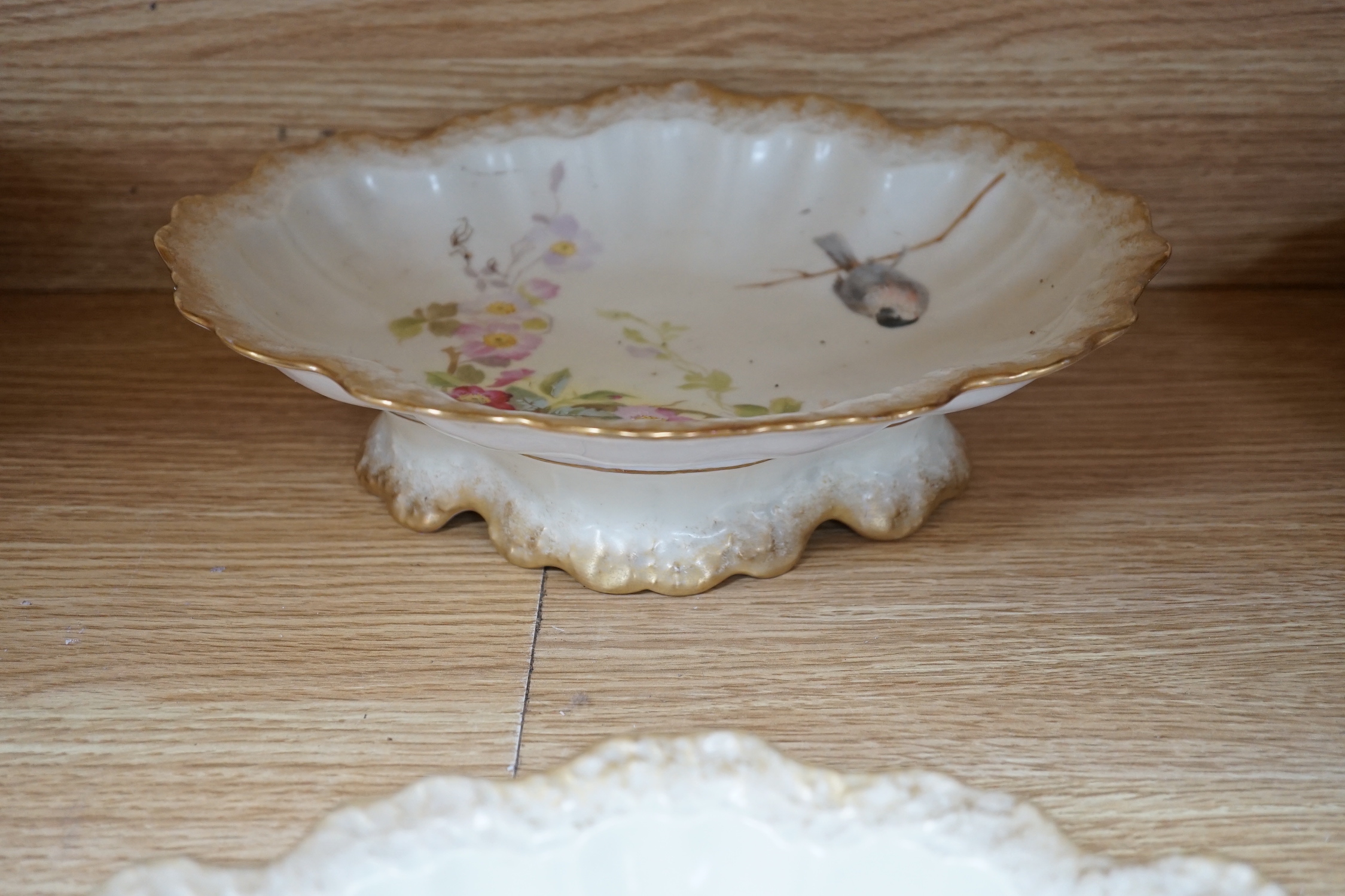 A Limoges dessert service decorated with birds and flowers, the largest 27cm wide